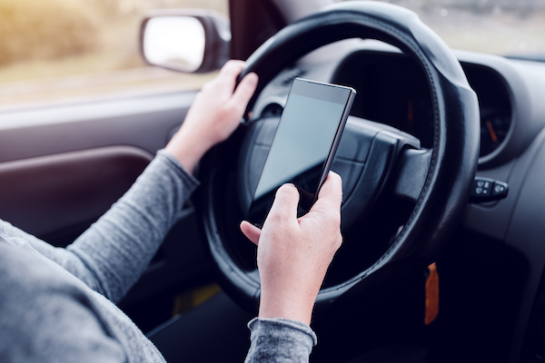 driver texting behind the wheel; Oklahoma distracted driving accident lawyer